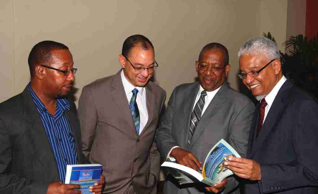 PHOTO COURTESY OF GraceKennedy Foundation L-R: Professor Ian Boxill, (Carlton Alexander Chair in Management), Don Wehby (GK Ltd Group CEO), Professor Dale Webber (James Moss-Solomon Sr Chair in Environmental Management) and Professor E. Nigel Harris glance through the textbook ‘Revista de Biologia Tropical’, edited by Prof. Dale Webber during the GKF/UWI Chair Press Conference on November 18, 2014 at the Council Room, UWI Regional Headquarters.